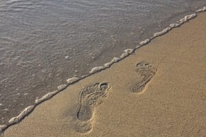 Il coraggio di compiere il primo passo impronte sulla spiaggia
