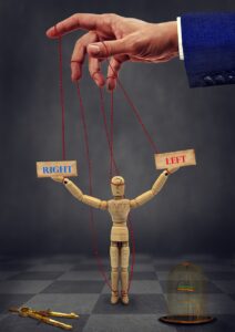 La rivincita della mano sinistra Mano che indica la sinistra con appeso un burattino con 2 cartelli: destra e sinistra