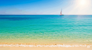 28 luglio giornata mondiale della conservazione della natura Mare visto dalla spiaggia con una barca a vela all'orizzonte.